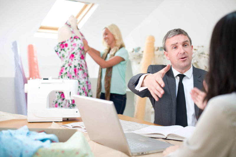 Man conducting a meeting in a fashion design showroom, project management software for small business concept